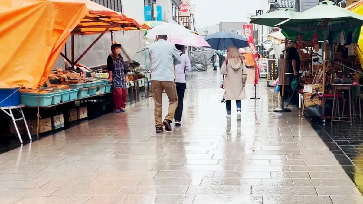 雨中の「輪島の朝一」を歩く飼い主たち。出店数も少なめ？