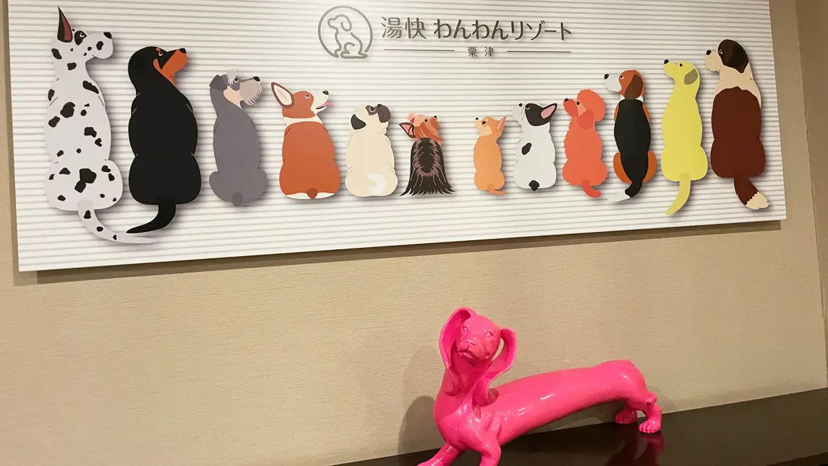 「湯快わんわんリゾート-粟津」さんの看板。わんこがズラリ並んでいて、真ん中にはヨーキーが！