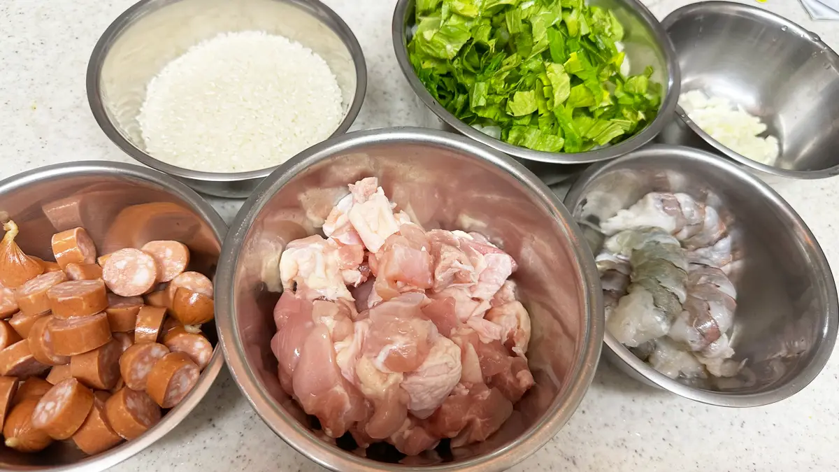細かく切った材料が入ったボウル(左上から米、野菜(Holy Torinity)、にんにく、ソーセージ、鶏もも、エビ)