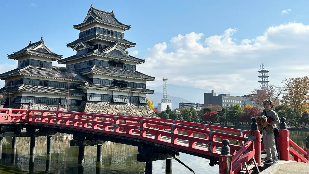 『松本城」の堀を渡るように建てられた赤い橋。その前で記念撮影するヨーキーズ(テリー&リアン)と人間(けい)