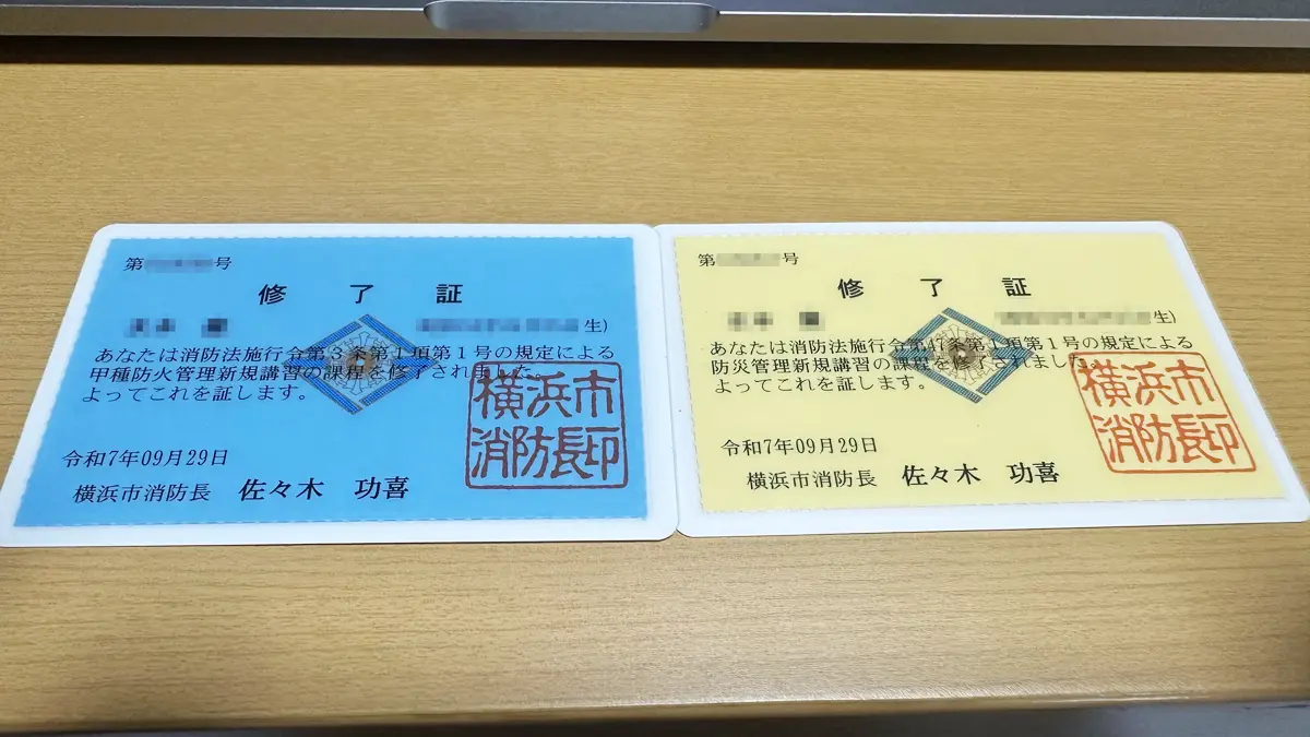 左側に青色の甲種防火管理者、右側に黄色の防災管理者の修了証