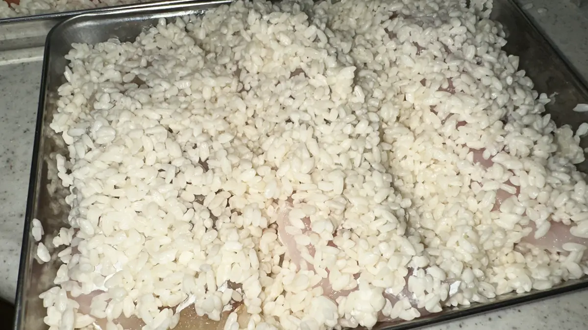 バットに湿らした米こうじを広げ、鱈を漬けている様子。