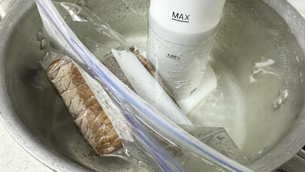 タマリンエンペラーの低音調理器を鍋に入れ、真空状態にしたお肉を沈めている様子