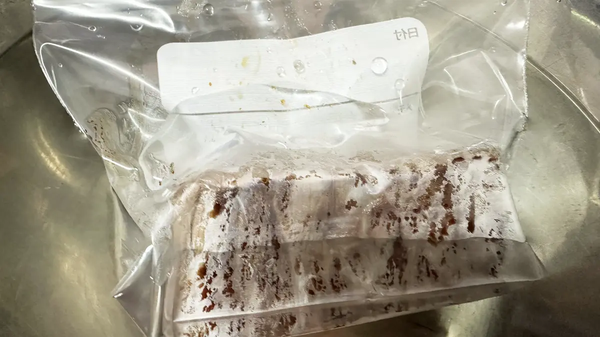 保存袋にお肉を入れ、水に沈めながら中の空気を抜いている様子