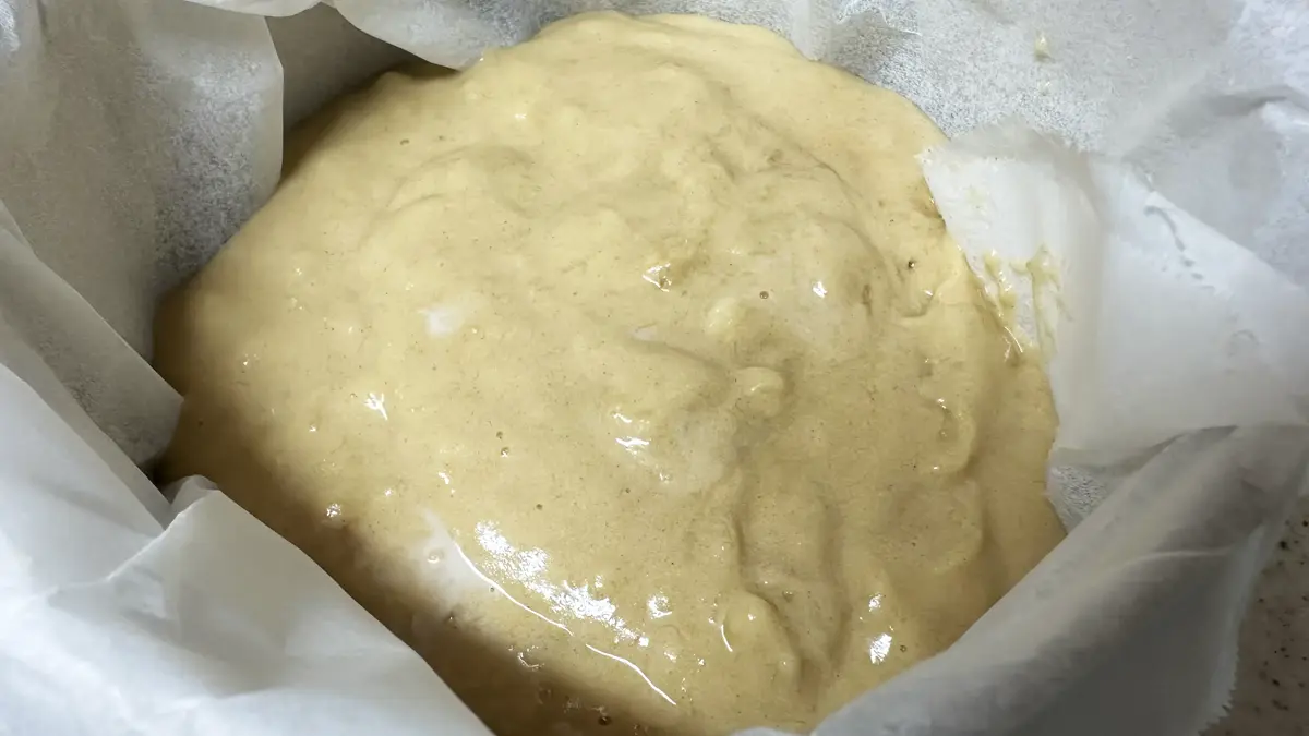 丸型の焼き型にクッキングシートを敷き、生地を流し込んでいる様子